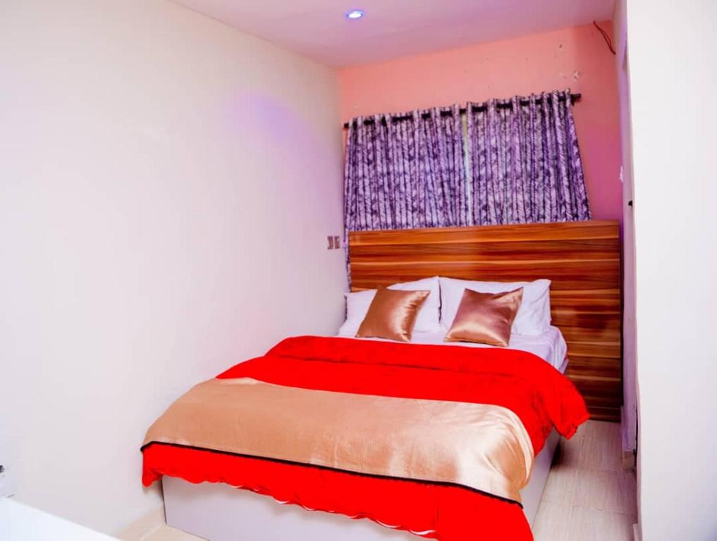 a bedroom with a red bed and a window at Hexagon Hotel Lounge & Restaurants. in Asi