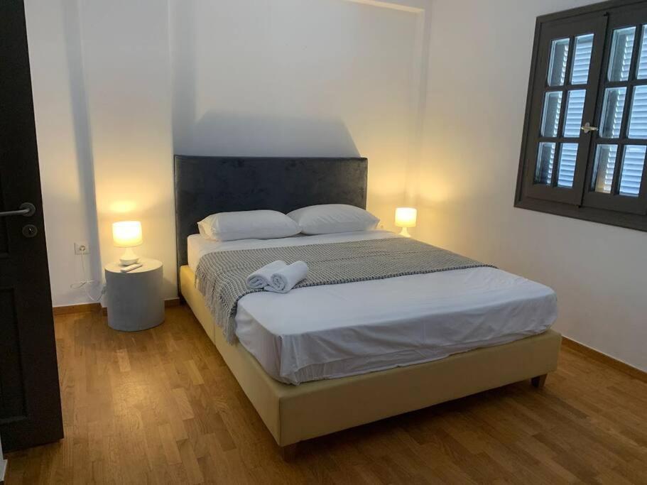 a bedroom with a large bed with two lamps at The Blue Lagoon Apartment in Aliki