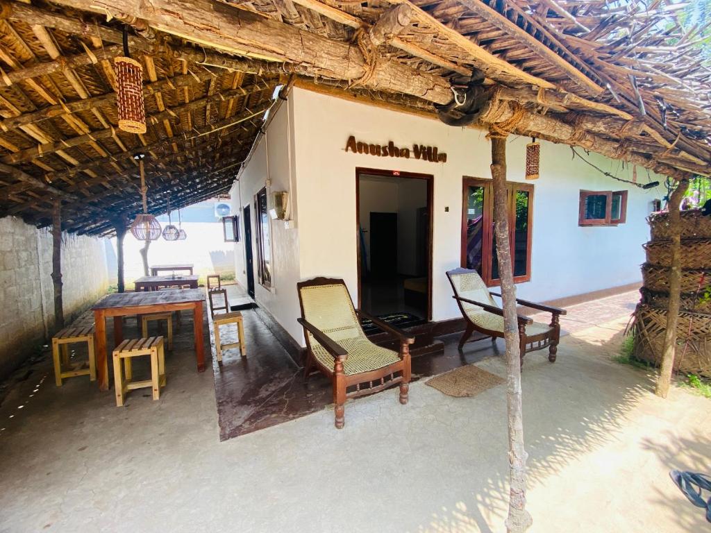 a porch of a house with chairs and a table at Anosha Villa in Weligama