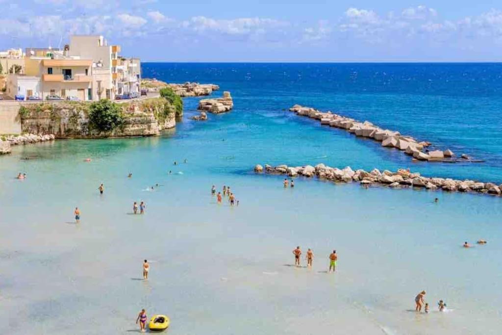 un gruppo di persone in acqua su una spiaggia di House Pedone a Otranto