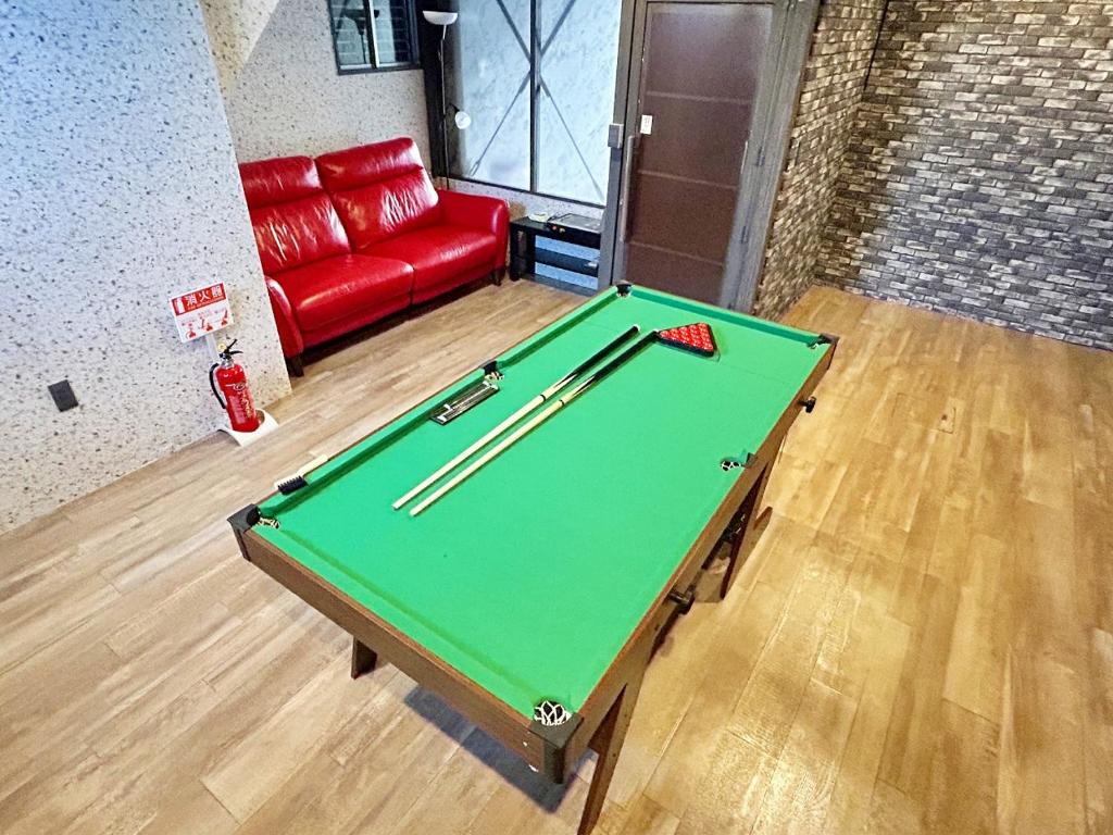 a pool table in a room with a red couch at 麗base野芥 in Fukuoka