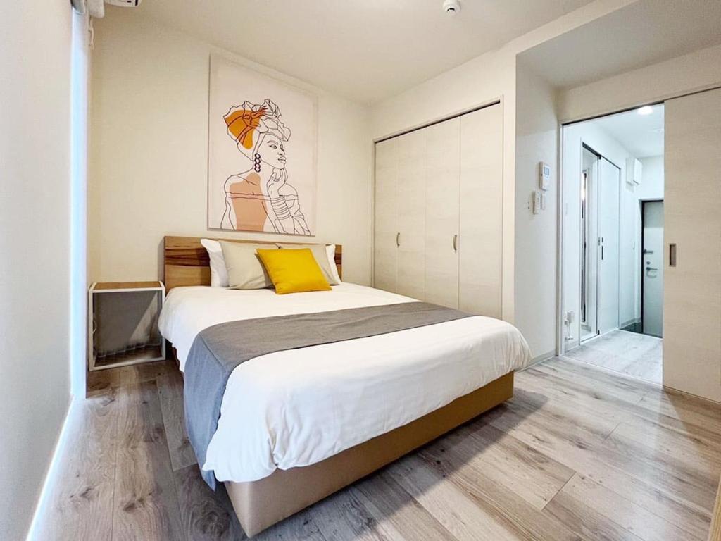 尾道市bHOTEL Yutori - Nice Apt in Onomichi near the Station for 3Ppl的一间卧室配有一张带黄色枕头的大床