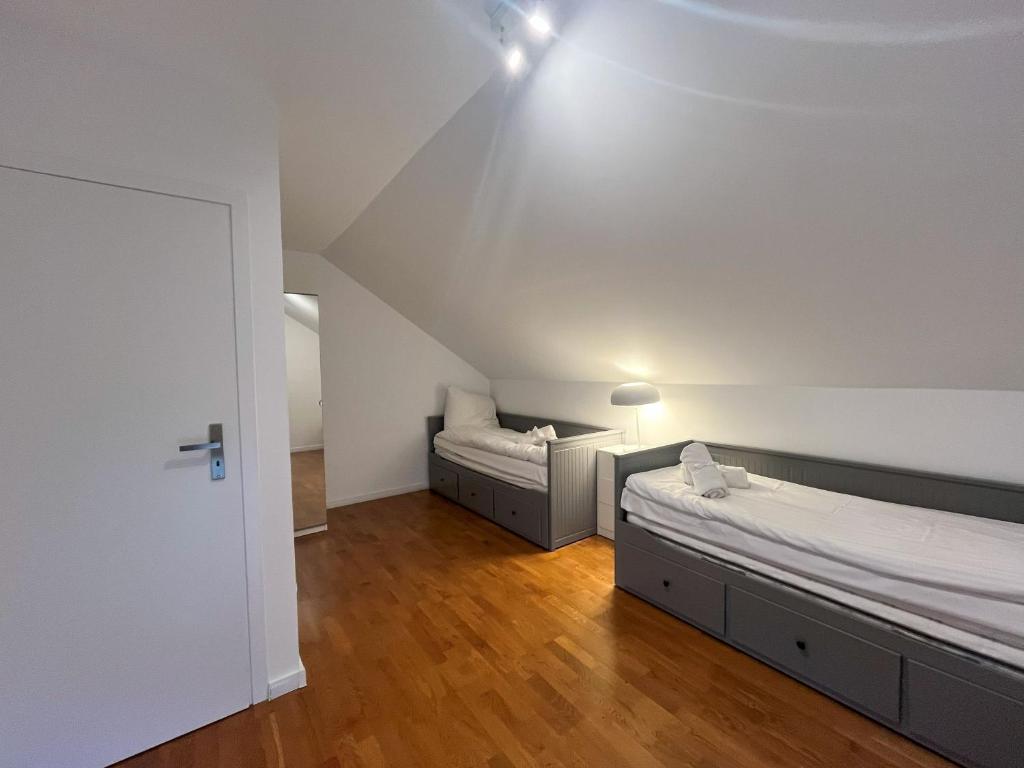 1 dormitorio con 2 camas y pared blanca en NordApart Strand Domek Jastrzębia Góra en Jastrzębia Góra