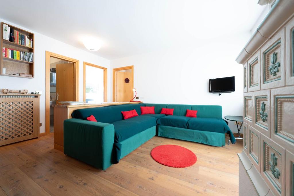 uma sala de estar com um sofá azul e almofadas vermelhas em Cesa Azola em Vigo di Fassa