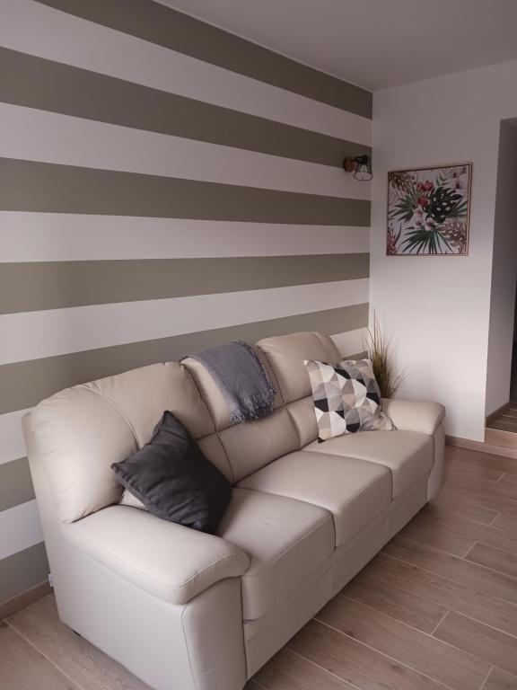 a couch in a living room with a striped wall at Little House Pove del Grappa in Pove del Grappa