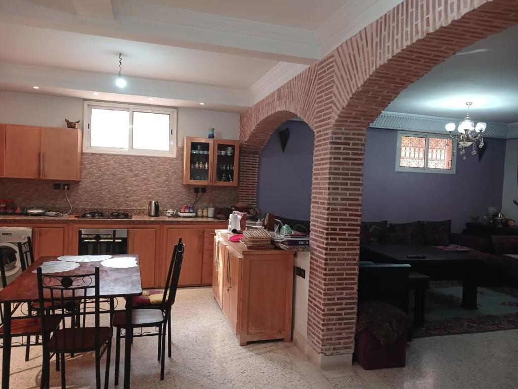 uma cozinha e sala de jantar com um arco de tijolos em Villa Mima em Marrakech