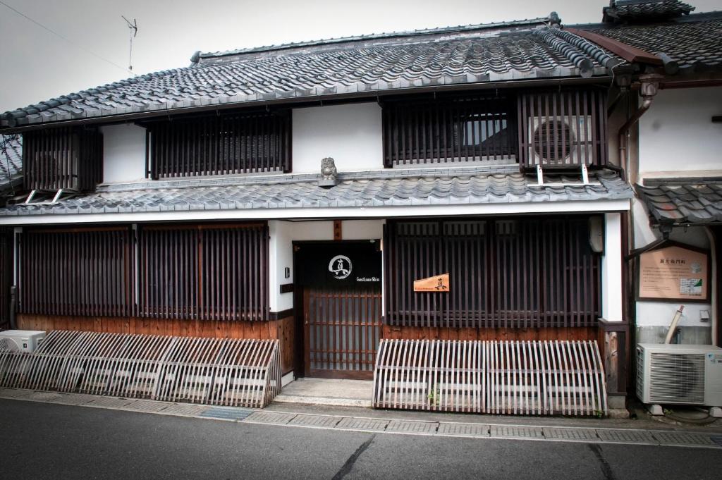 a building with a gate in front of it at Guesthouse Shin in Omihachiman