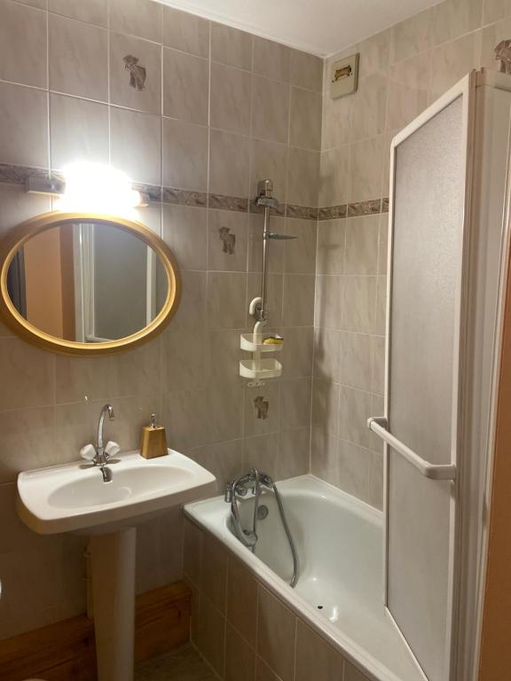 a bathroom with a sink and a tub and a mirror at Appartement au cœur de Seyne in Seyne