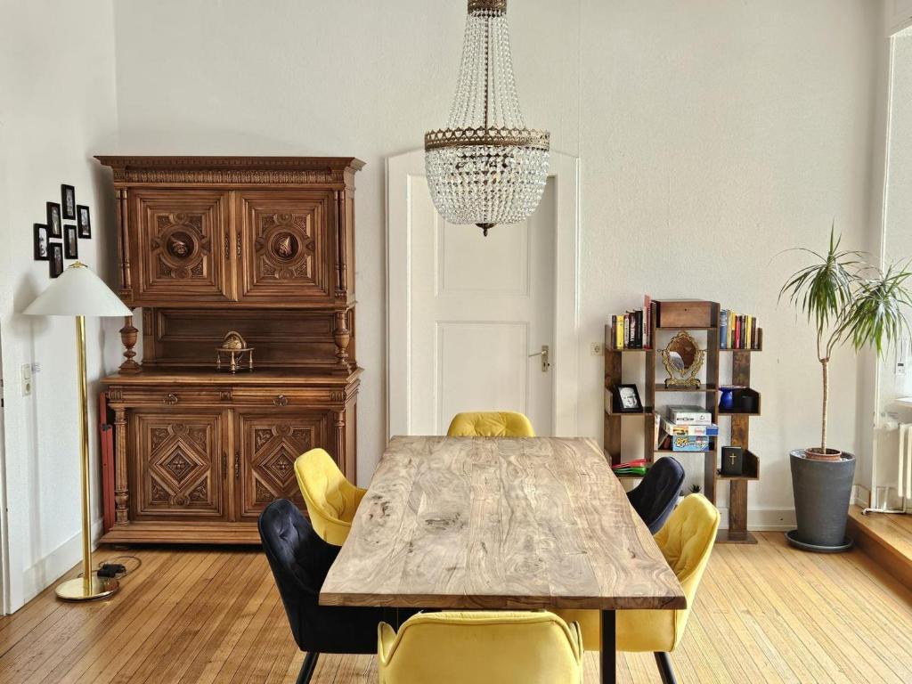 une salle à manger avec une table en bois et des chaises jaunes dans l'établissement Residence am Rathausplatz 3, à Sarrebruck