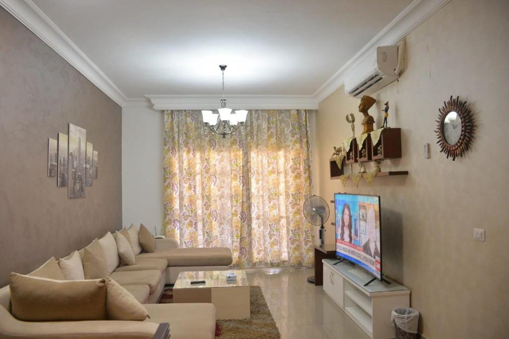 a living room with a couch and a television at Sharm Best Holiday in Sharm El Sheikh