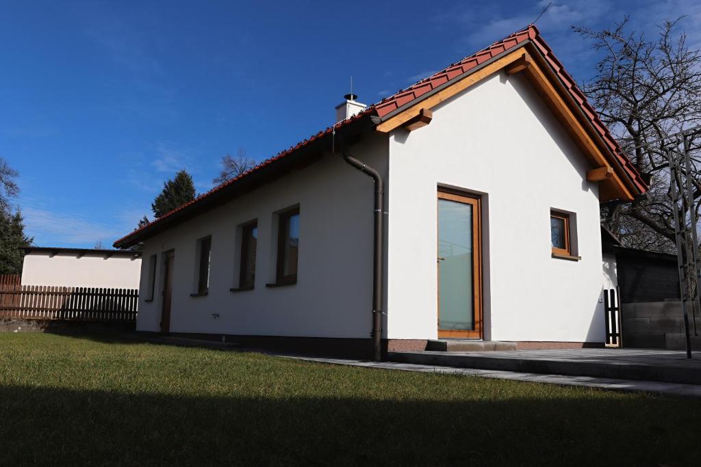 a white house with a red roof at Apartmán na Karlíčku in Karlov