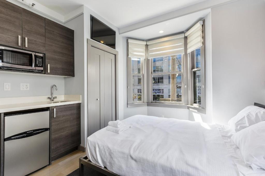 1 dormitorio con cama blanca y microondas en Calista Organic Hotel en San Francisco