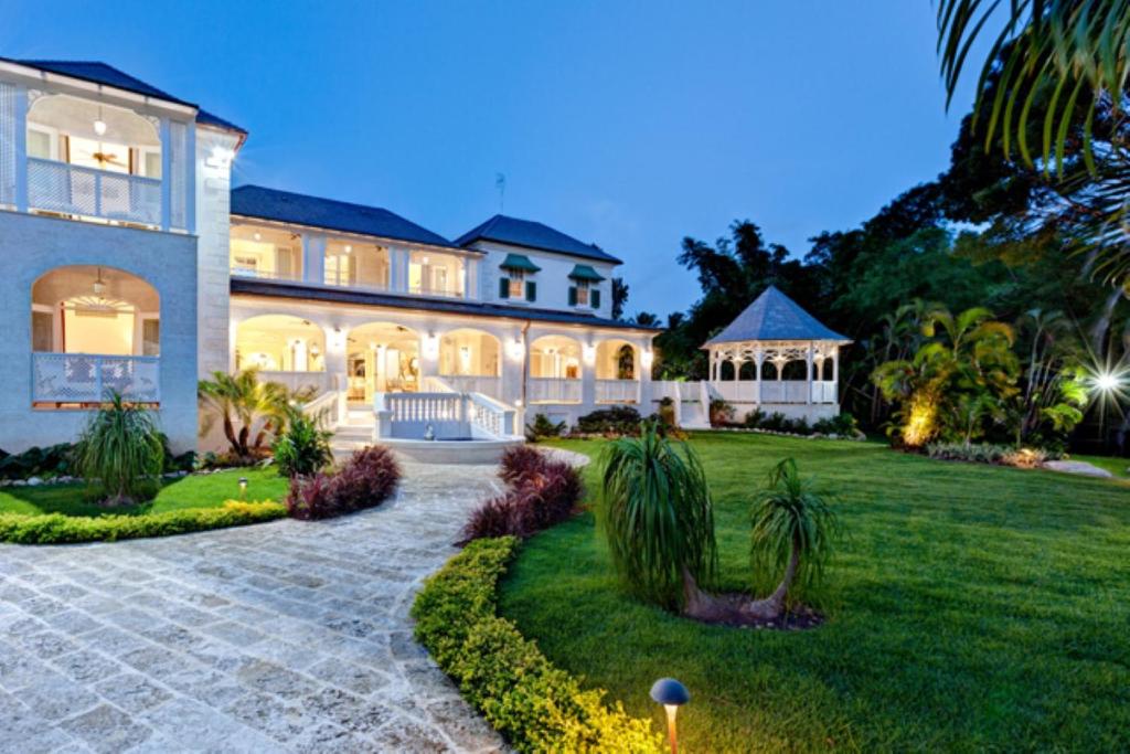 una casa grande con césped delante en Luxury 5 BR Villa in Sandy Lane en Saint James