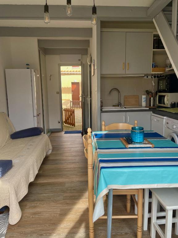 - une cuisine avec une table au milieu d'une pièce dans l'établissement Charming duplex maisonette - Lv-Ll-Clim - Les Charmilles, aux Mathes