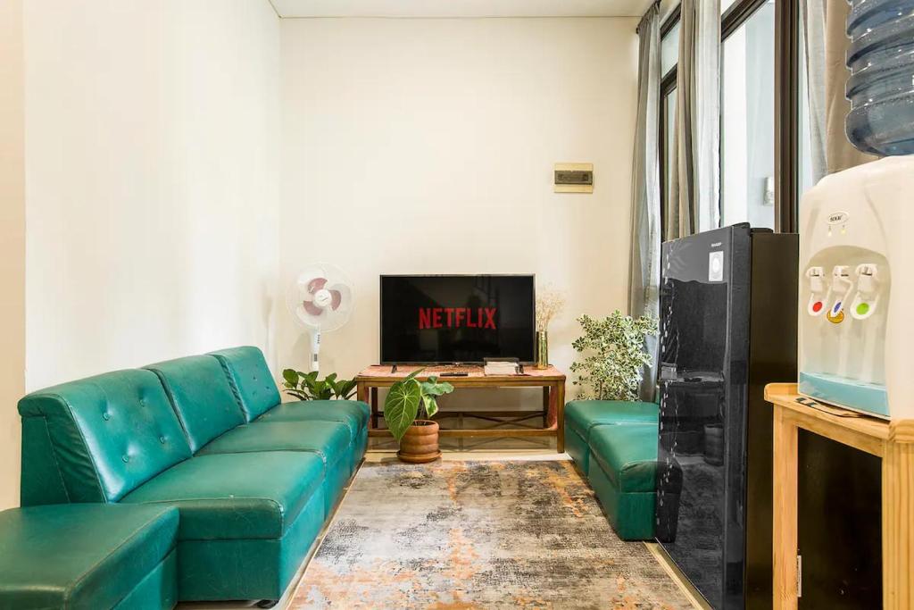 a living room with a blue couch and a tv at Cebu city entire place for family or party in Cebu City