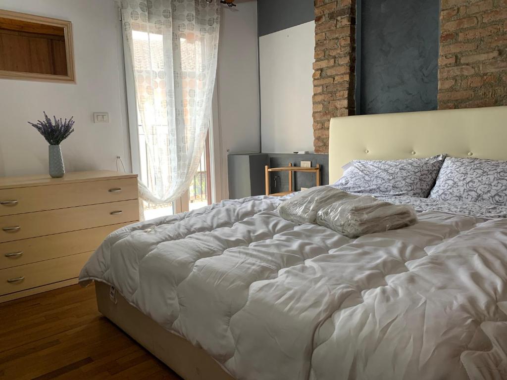 1 dormitorio con 1 cama blanca grande y vestidor en Casetta fra ely, en Meda