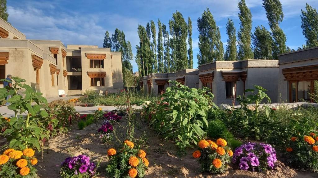 un jardín con flores frente a un edificio en Nordica Resorts Ladakh, en Leh