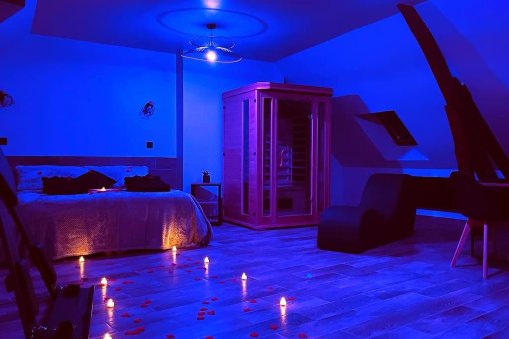a bedroom with a bed with candles on the floor at Love Room Le Chalet / Jacuzzi / Sauna in Château-Landon