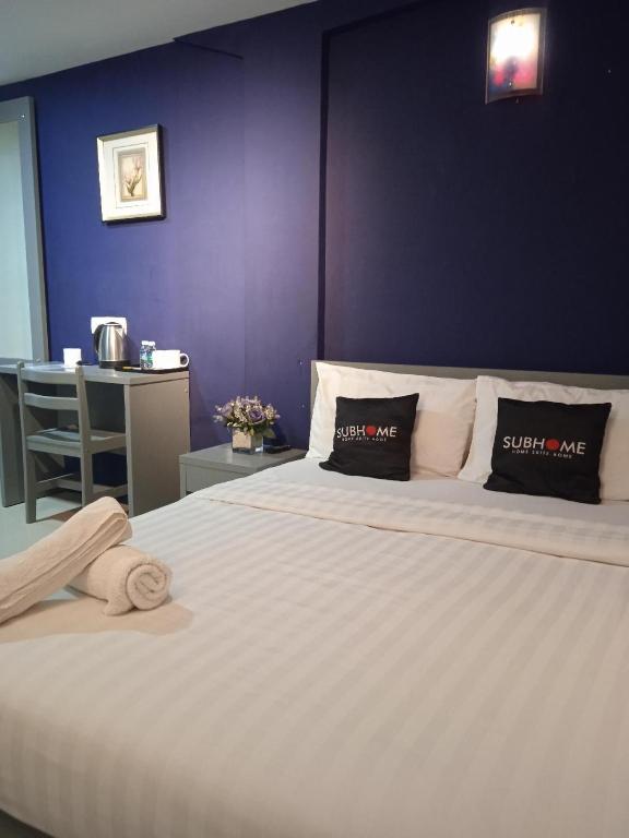 1 dormitorio con 1 cama blanca grande y pared morada en Alia Express Brickfields en Kuala Lumpur