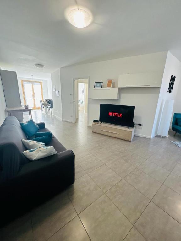 a living room with a couch and a tv at L'oro del lago monate lake - Ixihome in Travedona