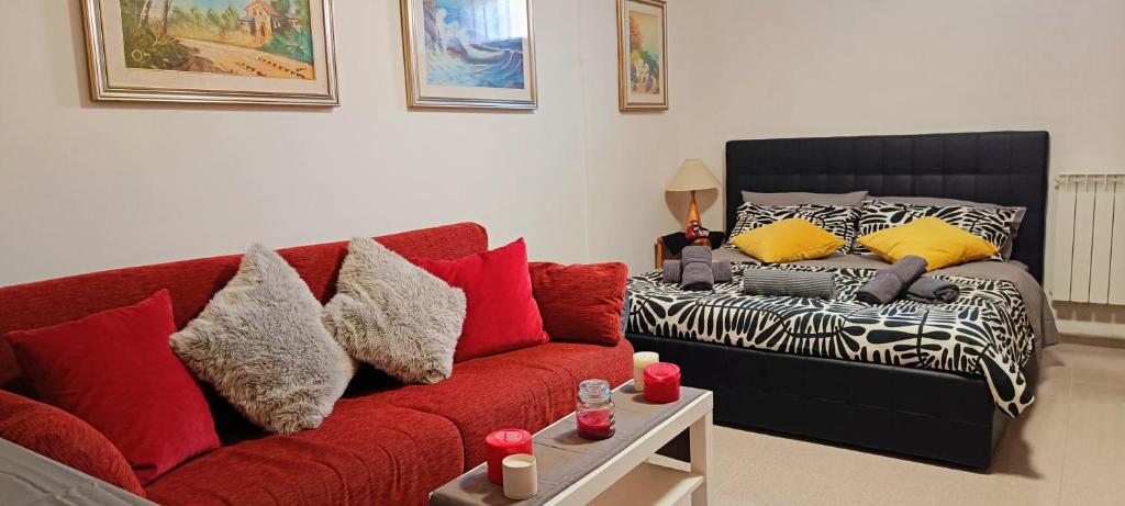 a living room with a red couch and a bed at FAMILY VILLA SUITE in Rome
