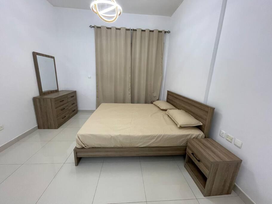 a bedroom with a bed and a mirror and a dresser at Newly Furnished Studio in Elite in Dubai