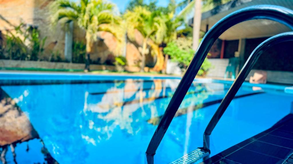 een zwembad met blauw water en palmbomen bij Villa De Lanerolle in Attidiya