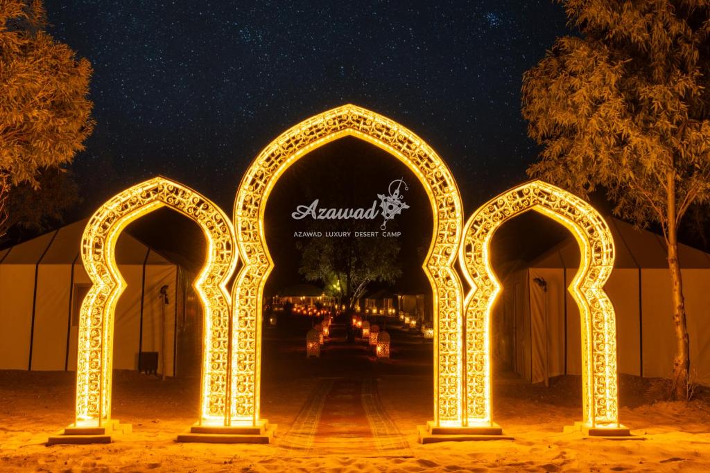 Un arco con luces en una calle por la noche en Azawad Luxury Desert Camp, en Merzouga