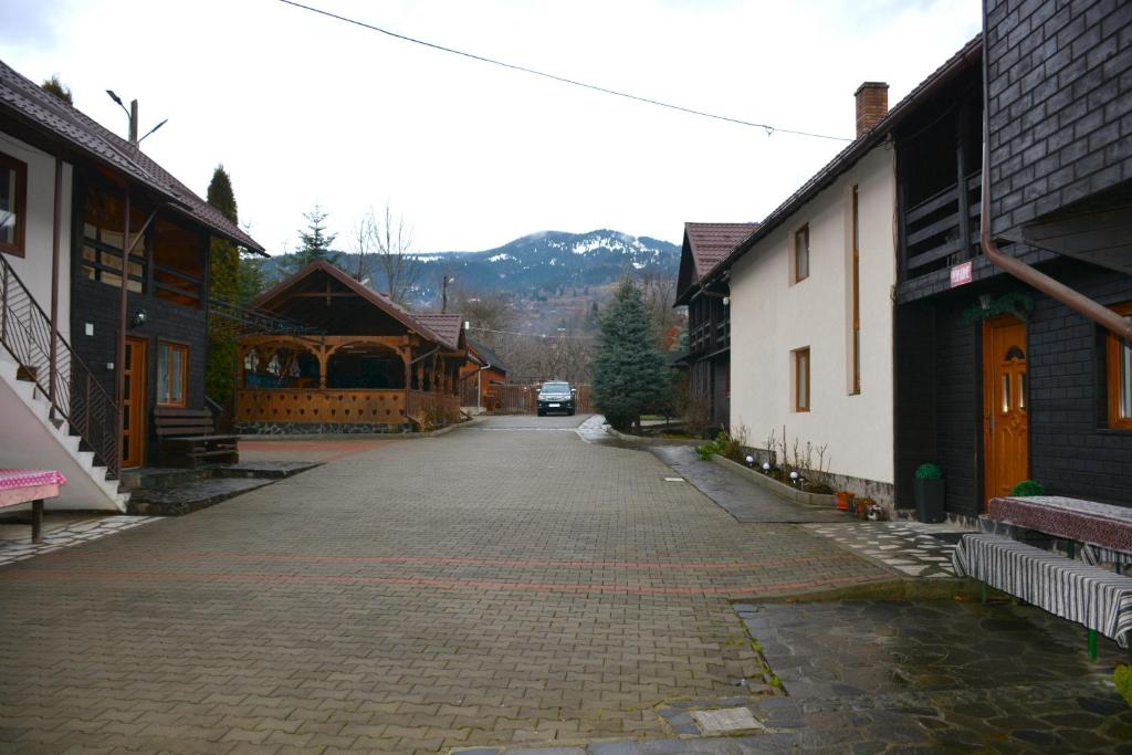 an empty street in a town with buildings and a car at Pensiunea Poiana in Borşa