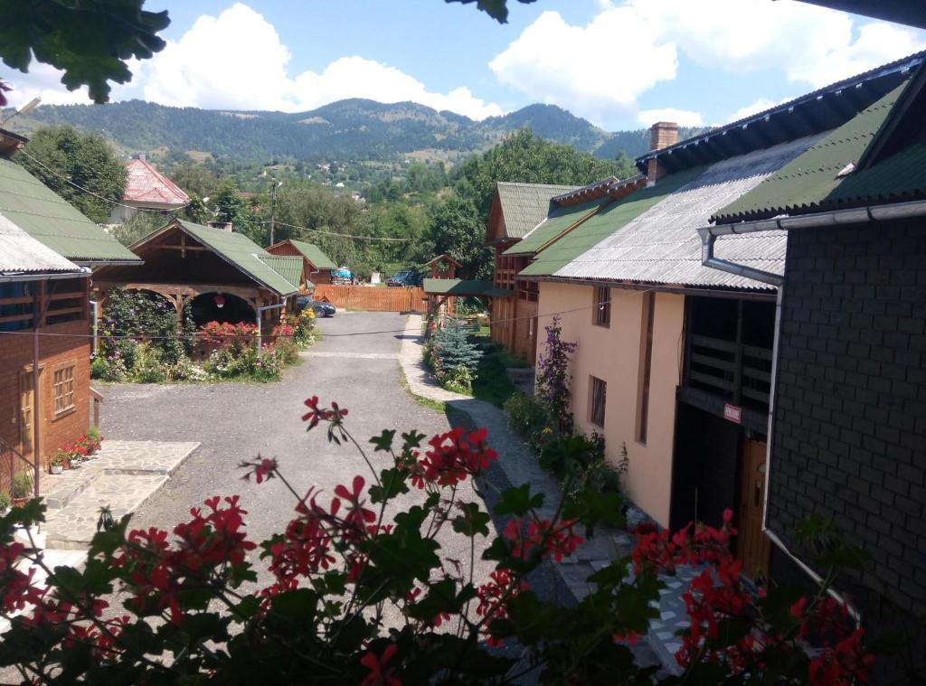 an empty street in a village with mountains in the background at Pensiunea Poiana in Borşa