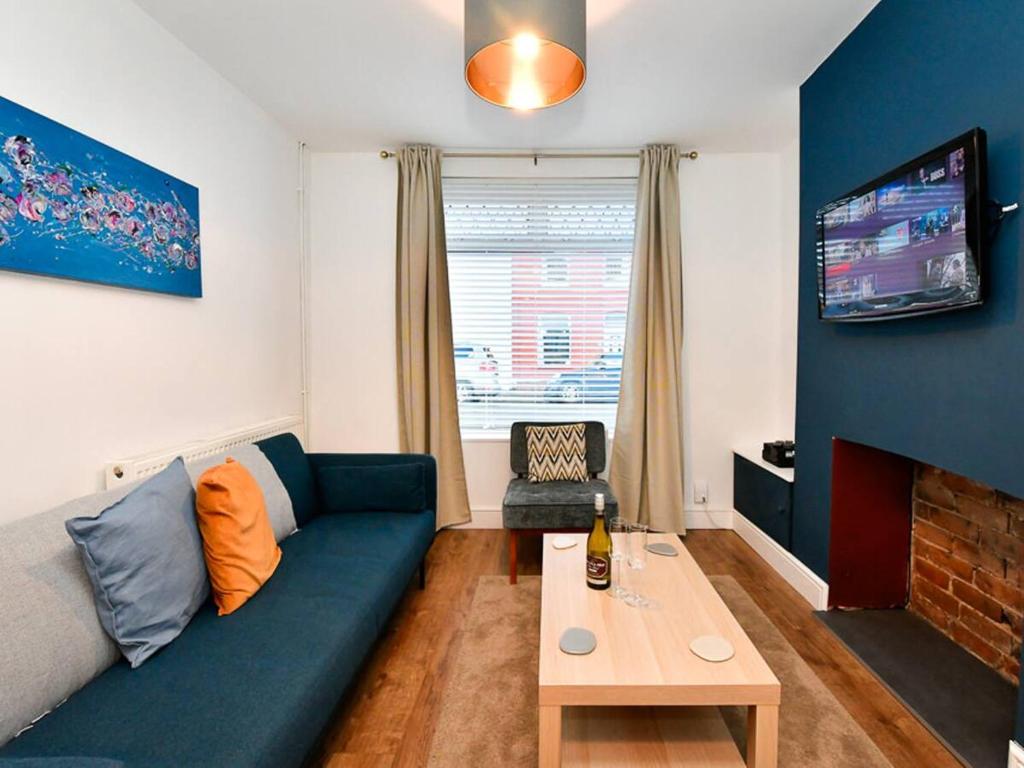 ein Wohnzimmer mit einem blauen Sofa und einem Tisch in der Unterkunft Pass the Keys Cosy 2 bed home in Pontcanna in Cardiff