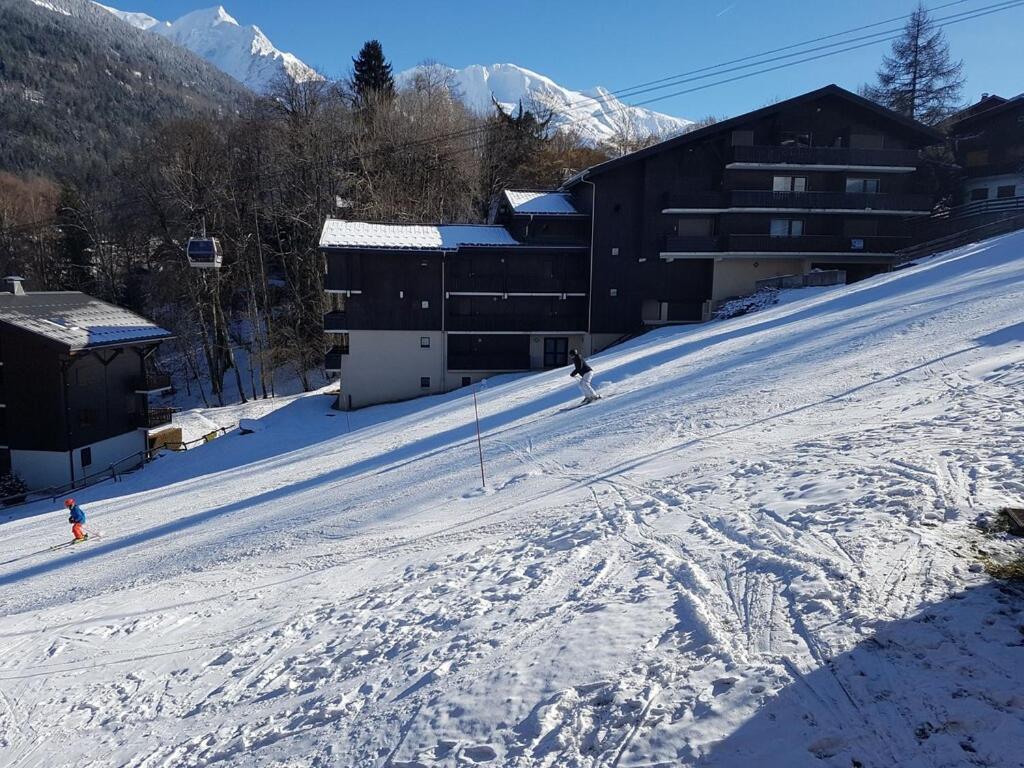 un grupo de personas esquiando por una pista cubierta de nieve en Etoile des Alpes, en Saint-Gervais-les-Bains