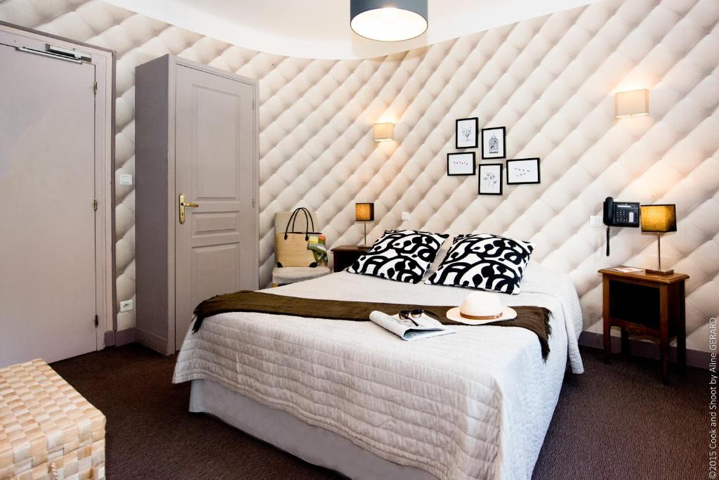 a bedroom with a large white padded wall at Logis Hôtel La Magnanerie - Côté Bistro in Aubignosc