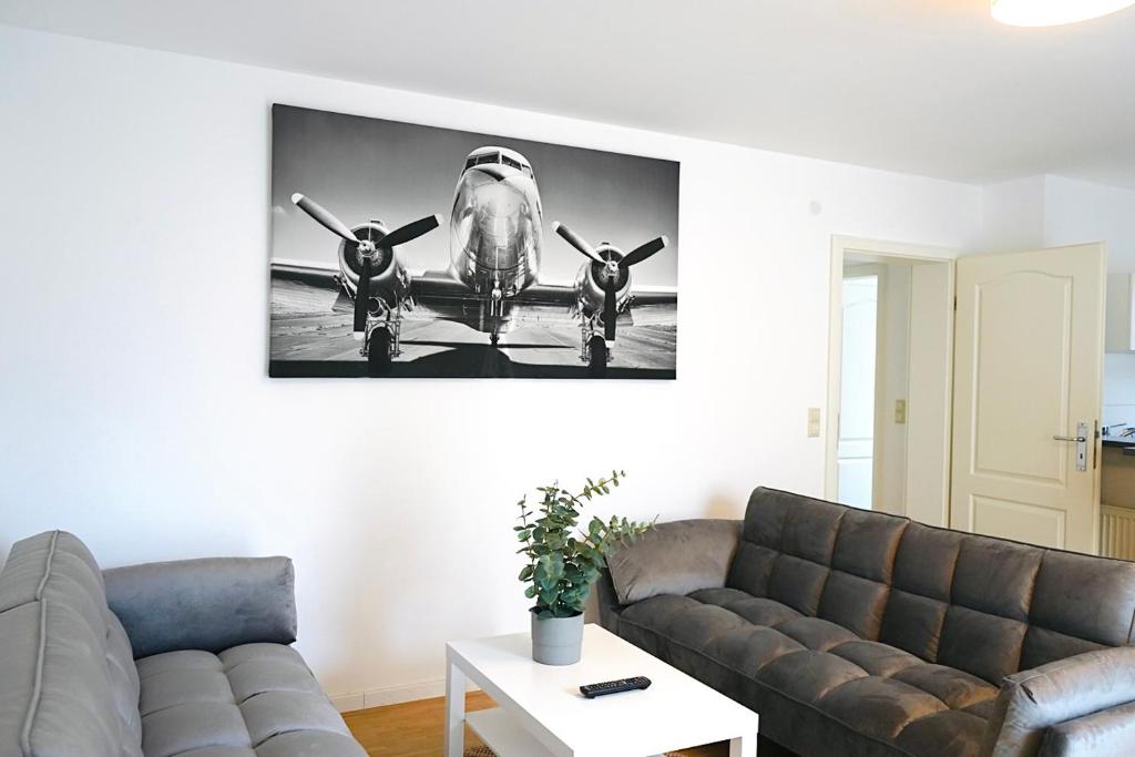a living room with a couch and a picture of a plane at Stilvolles und ruhiges Apartment in stadtnähe in Wolfsburg