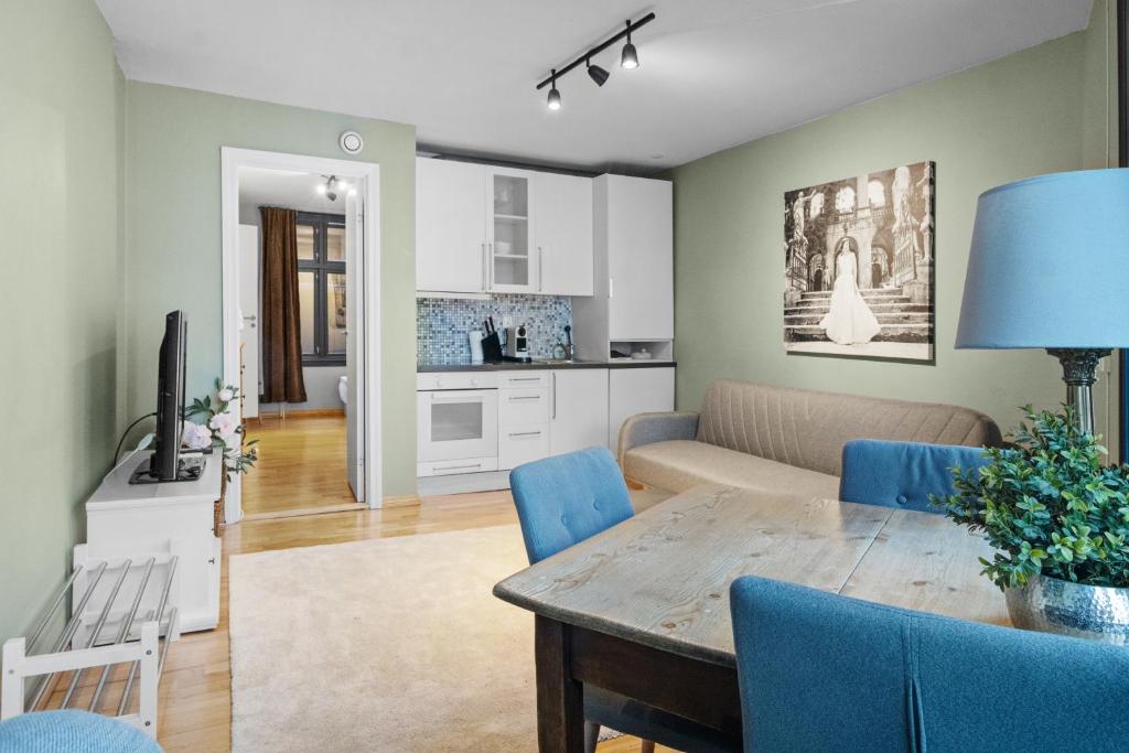 ein Wohnzimmer mit einem Tisch und blauen Stühlen in der Unterkunft Peaceful Urban Residence in Bergen