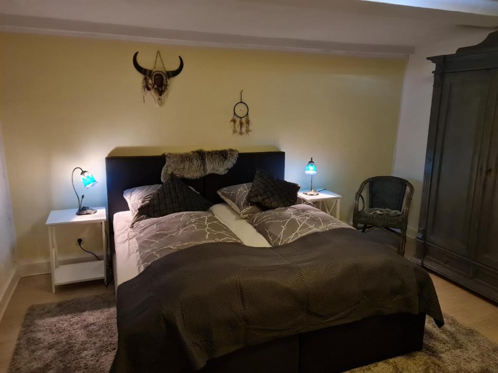 a bedroom with a bed with two lamps on two tables at Pension Hagzissa in Laubhütte