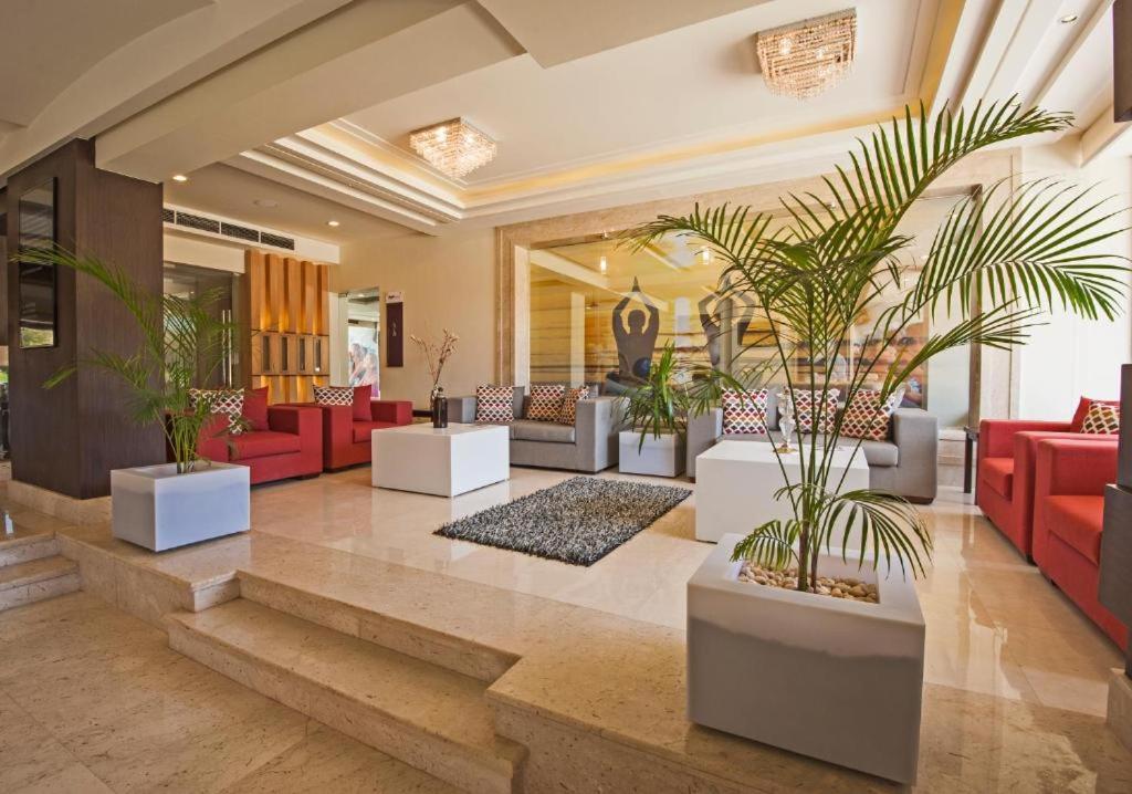 um átrio com mobiliário vermelho e vasos de plantas em Rivoli Suites and Spa em Hurghada