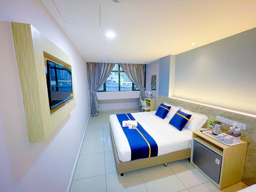 クアラルンプールにあるStarQ Hotel Kuala Lumpurのベッドとテレビが備わるホテルルームです。
