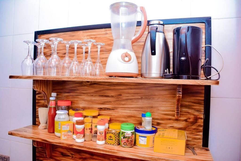 a wooden shelf with a blender and bottles on it at Iwawe by IBC- Entire house in Kigali