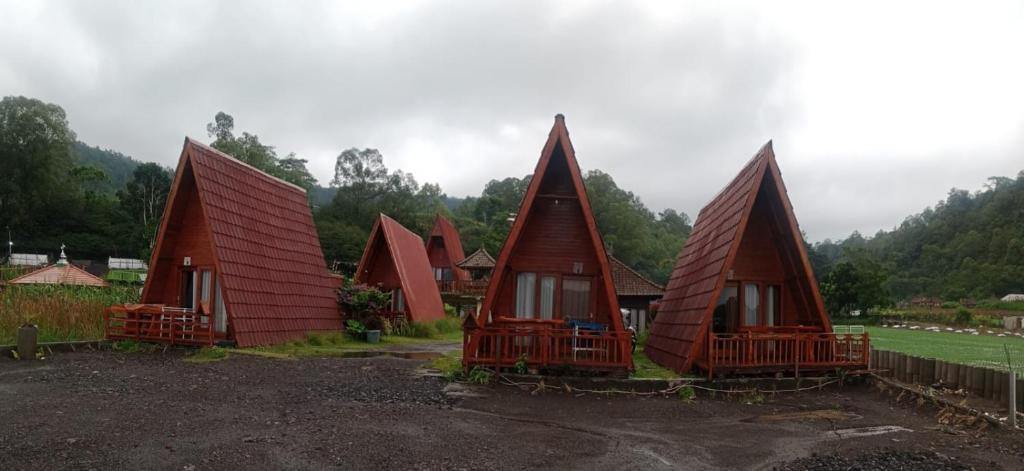 um grupo de pequenas casas com telhados vermelhos em Astradana Hotel & Glamping em Kintamani