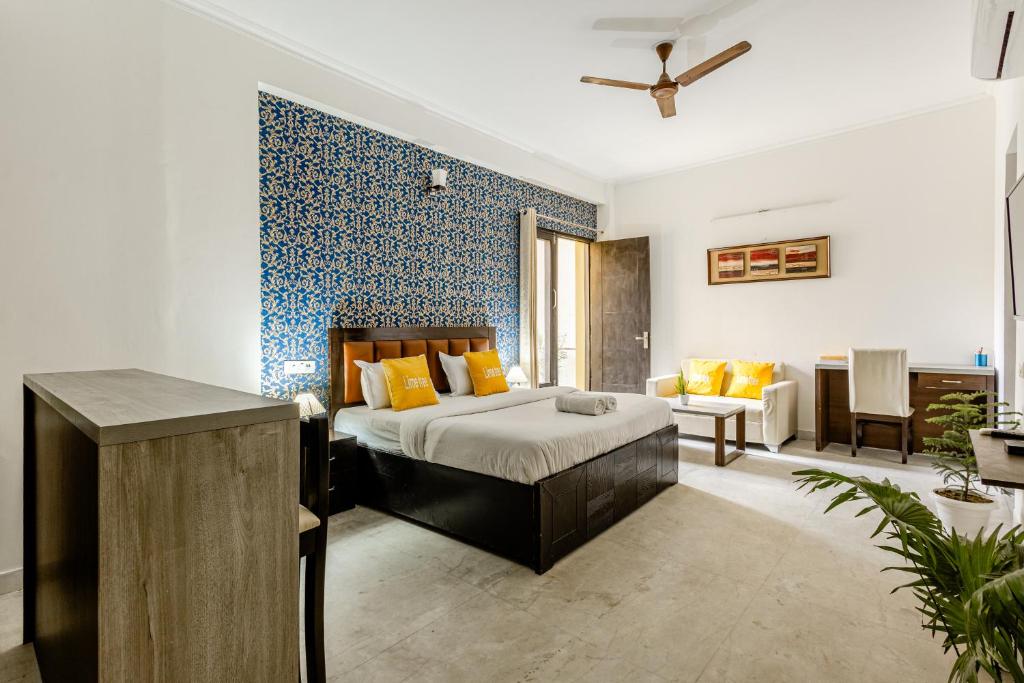Lime Tree Service Apartment Golf Course Road, Gurgaon في جورجاون: غرفة نوم مع سرير وغرفة معيشة