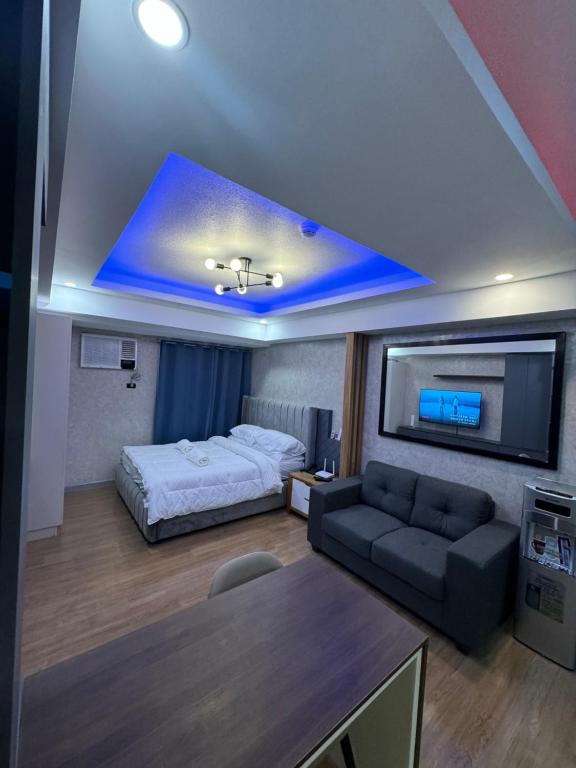 Habitación con cama, sofá y TV. en Abreeza Place T2 - 720 en Davao