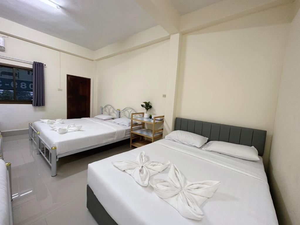 Cette chambre comprend 2 lits avec des draps blancs. dans l'établissement Thong Sai Homstay BETONG -ทองใสโฮมสเตย์-, à Betong