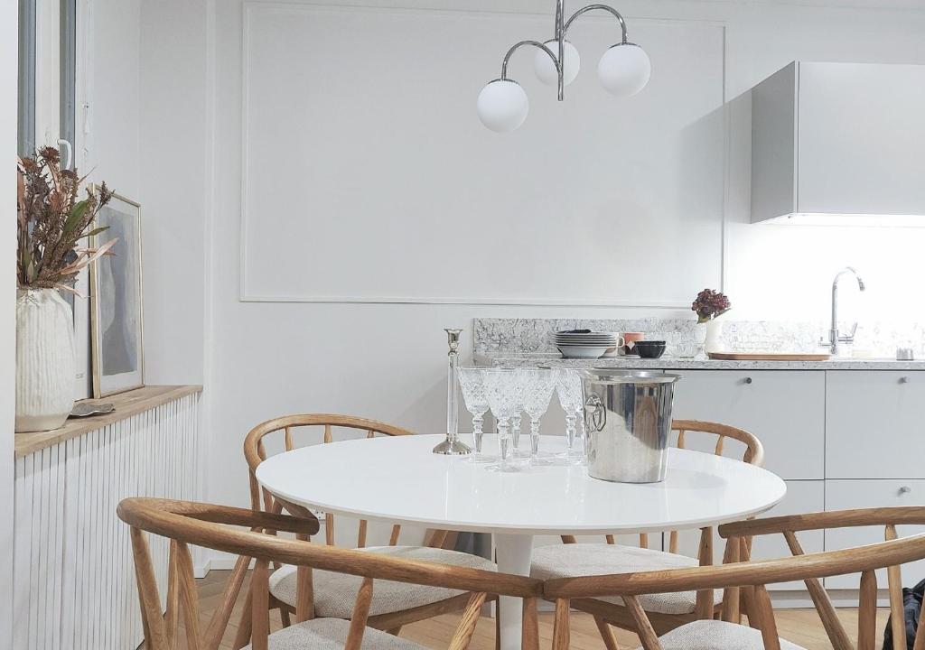 a white kitchen with a white table and chairs at Modern&Quiet 7th floor Apt with Balcony, Free 5G WIFI, Laukontori in Tampere