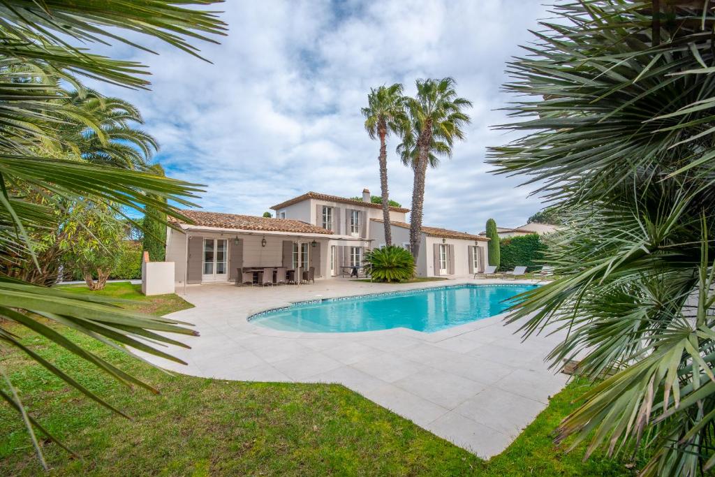 Villa con piscina y palmeras en Villa le Roi Soleil, en Saint-Tropez