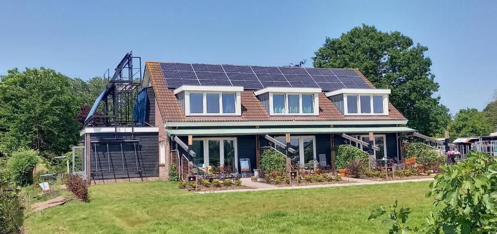 una casa con paneles solares en el techo en Huis over de dijk, en De Kwakel