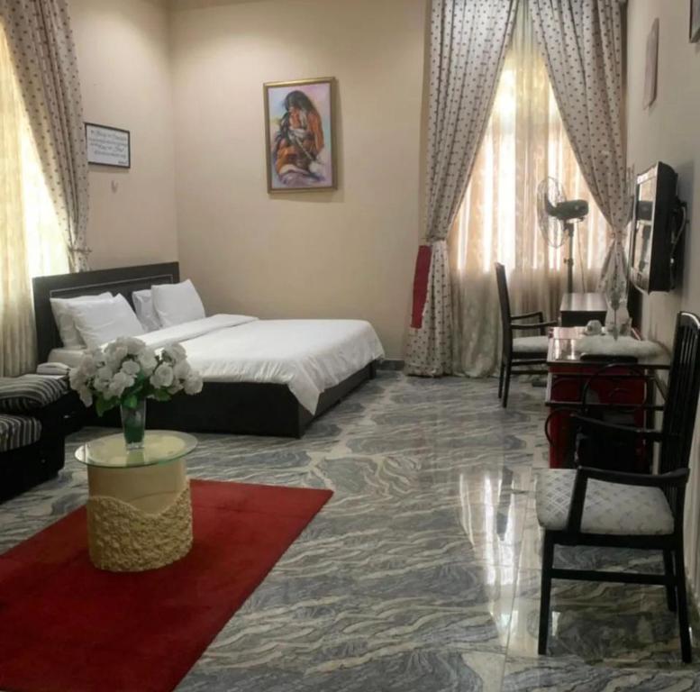 a hotel room with a bed and a living room at Teny Homes in Calabar