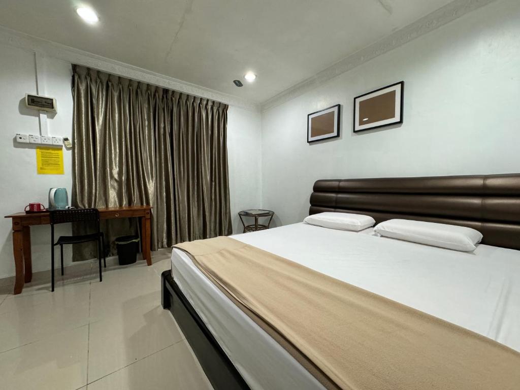 a bedroom with a large bed and a desk at Lan Village in Mersing