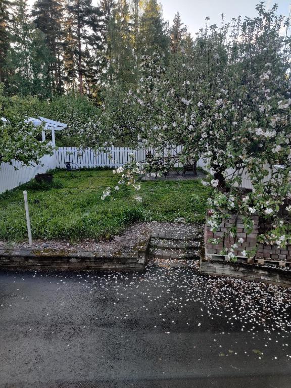 a fence with a flowering apple tree in a yard at Vintage Retreat in Lahti