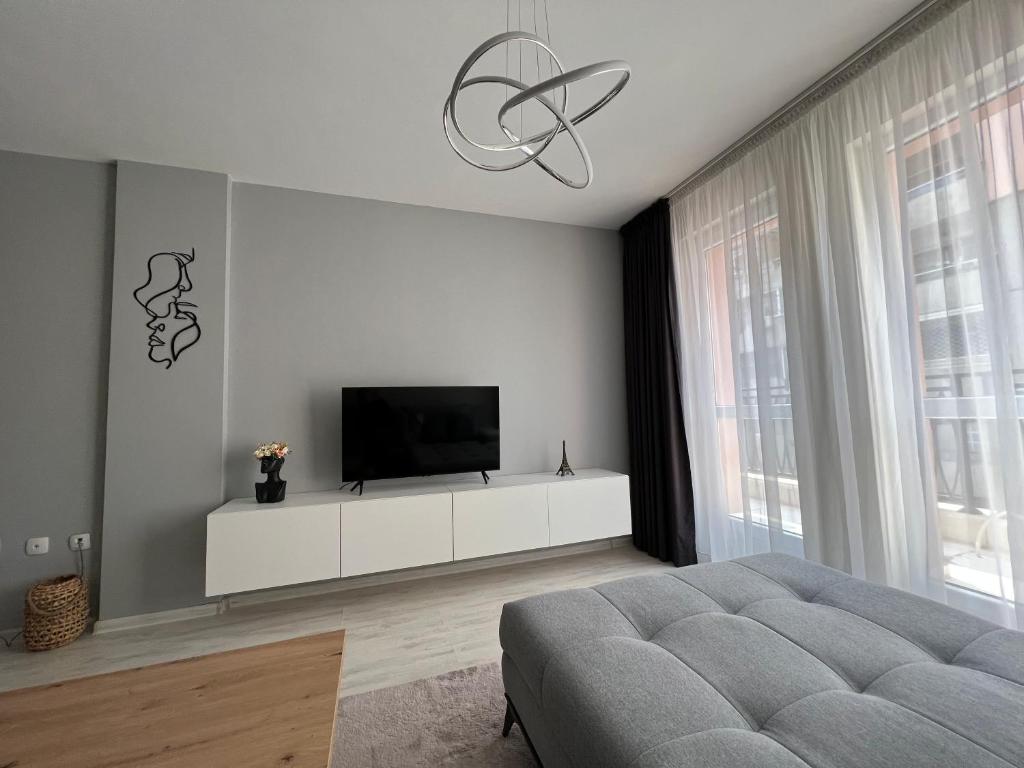 a living room with a television on a white cabinet at Soflu apartments Plovdiv in Plovdiv